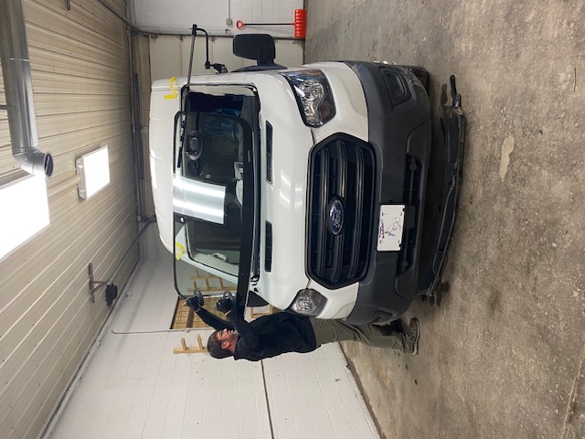 Professional technician working on vehicle windshield